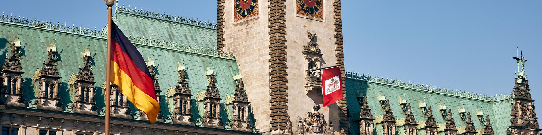 Bundesfahne und Senatsfahne wehen am Hamburger Rathaus